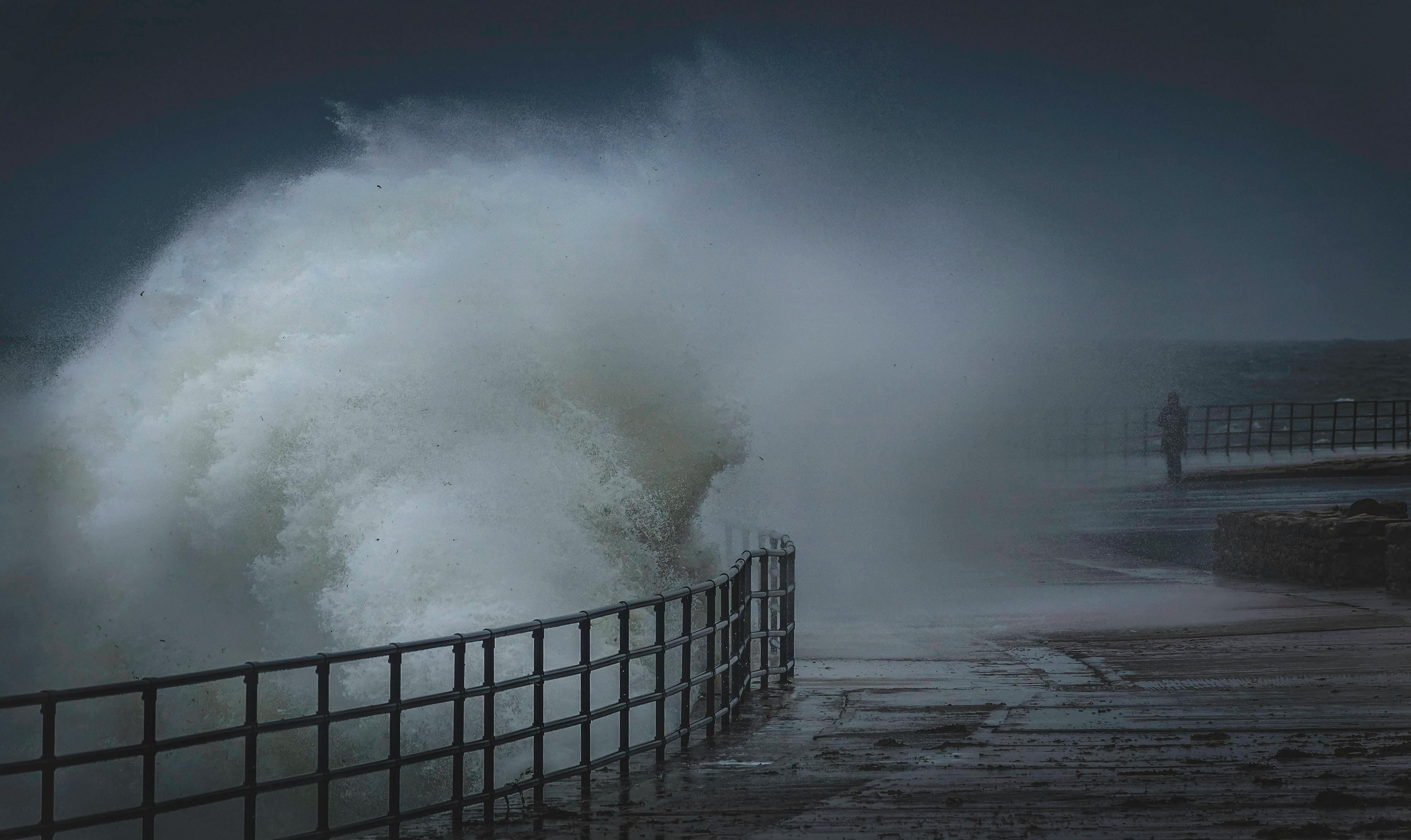 Ocean Waves Crashing on Embankment with Railings